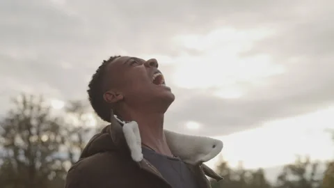 Dynamic shot of Angry Young Man Screaming while standing outdoors during day Stock Footage 208777827