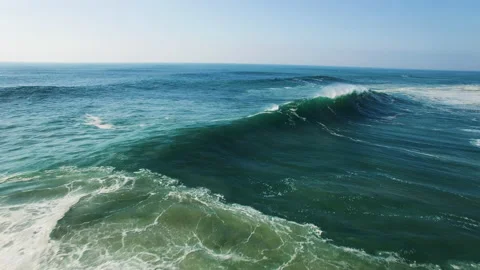 Dynamic shot of blue waves splashing in ocean during sunny day with blue sky Stock Footage 156611815