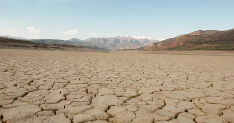 Dynamic shot of cracked soil ground of dried lake or river in mountains. Land Stock Footage 130598826
