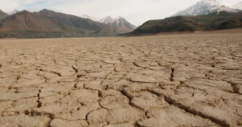 Dynamic shot of cracked soil ground of dried lake or river in mountains. Land Video stock 131186225