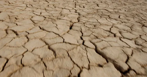Dynamic shot of cracked soil ground of dried lake or river in mountains. Land Stock-Footage 135355281