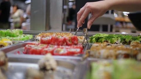 Dynamic shot of hands skillfully picking sushi with a specialized tool at a Stock Footage 314822948