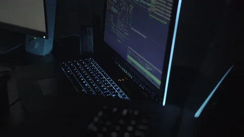 Dynamic shot of Laptop Running Code and hacking system in dark room Stock Footage 208745846