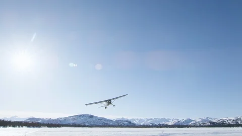 Dynamic shot of metal airplane flying above winter landscape of Alaska Stock Footage 129127761