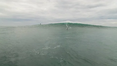 Dynamic shot of professional surfer riding on big ocean wave during cloudy day Stock Footage 163288751