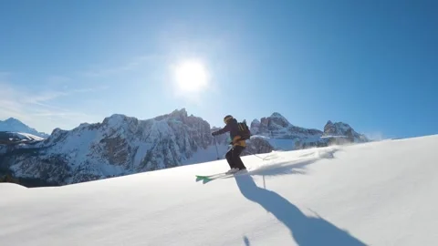 Dynamic Skier Navigating Pristine Snowy Mountains in Bright Sunlight Stock-Footage 323835646