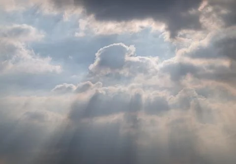 A dynamic sky filled with thick, dramatic clouds allows sunlight to stream .. Stockfoto's