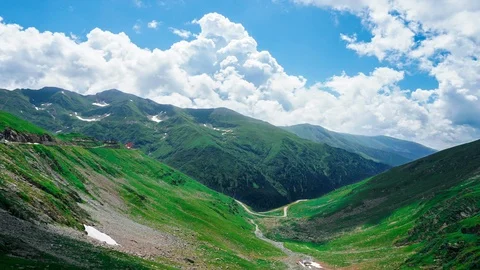 Dynamic sky over valley in mountain, rode with car and alone hose with red roof Stock Footage 123076341