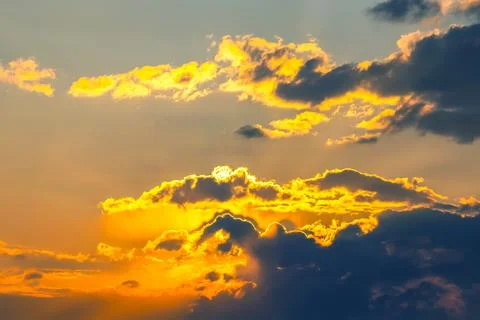 Dynamic sky with towering dark clouds and brilliant sunlight rays cutting t.. Stock Photos