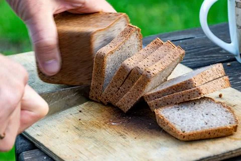 Dynamic slicing of rye bread captured with motion blur for action effect Foto stock