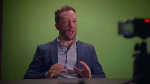 A Dynamic Speaker Positioned in Front of a Green Screen for Engaging Media Video stock 293221537