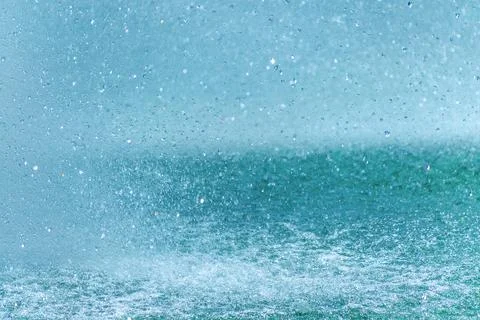 Dynamic splash patterns in cascading water drops against blue background Stock Photos