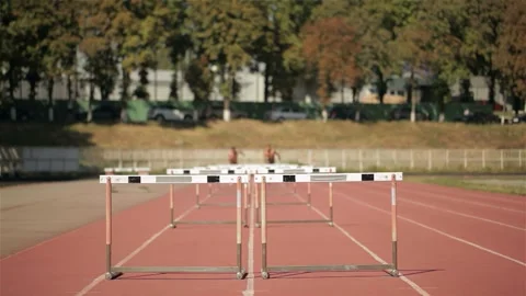 Dynamic sprinters soaring over hurdles in an exhilarating race Stock Footage 311535503