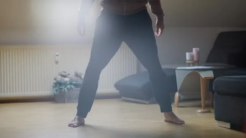 Dynamic Squat Exercise Featuring a Modern Stylish Living Room Setting for Stock Footage 308663578