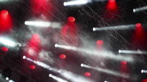 Dynamic stage lighting show with red and white beams cutting through smoke .. Video stock 339212187