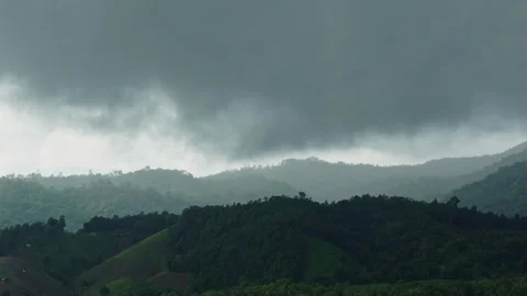 Dynamic storm clouds formation timelapse rolling over green hills and mountains Stock Footage 337285380