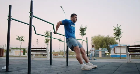 Dynamic Street Workout Engage in Parallel Bar Dips for Enhanced Strength Stock Footage 318073859