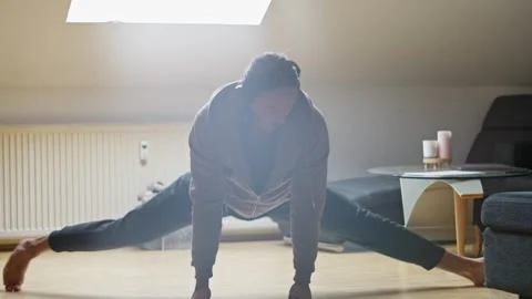 A Dynamic Stretching Pose is performed in a Bright Room filled with natural Stock Footage 302655436