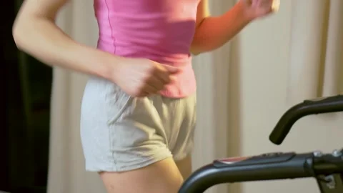 Dynamic stride of unrecognizable female body on treadmill during indoor cardio Stockbeeldmateriaal 334849283