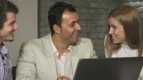 Dynamic team of business professionals laughing and collaborating at the office Stock Footage 311946653