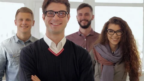 Dynamic team of four professionals confidently posing in a bright office Stock Footage 311181300