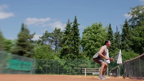 A Dynamic Tennis Player Engaged in Action on an Outdoor Court during a Stock-Footage 317779737