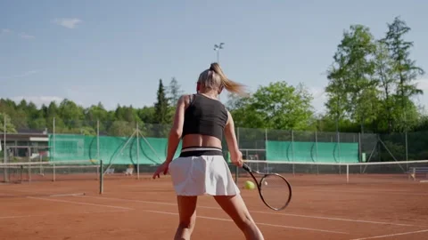 A Dynamic Tennis Player Engaging in Practice on a Clay Court, Showing Focus and Stock Footage 308416542
