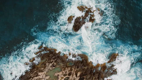 Dynamic tide surges through scattered coastal rocks from an aerial view Stock-Footage 341446667