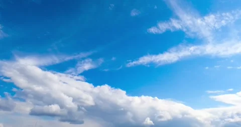Dynamic time-lapse of fluffy white clouds dancing across a vibrant blue sky.. Stock Footage 337538743
