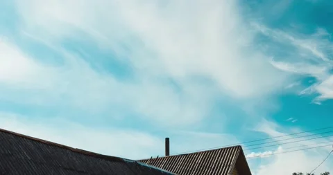 Dynamic timelapse of fast moving clouds over a farmhouse with a chimney Stock Footage 139804531