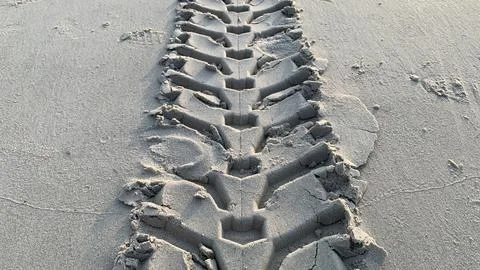 Dynamic tire tracks on sandy beach perfect for adventure, travel Stock Photos