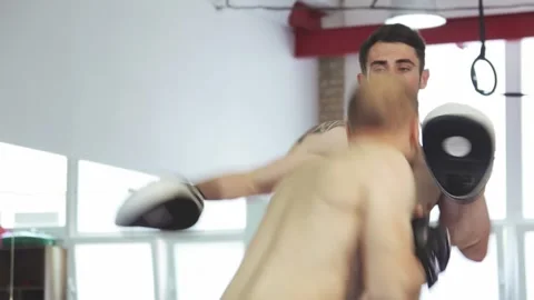 Dynamic training session between muscular MMA coach and male fighter Stock Footage 311536598