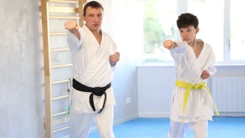 Dynamic underage boy performing fighting positions in row during karate courses Video stock 284685603
