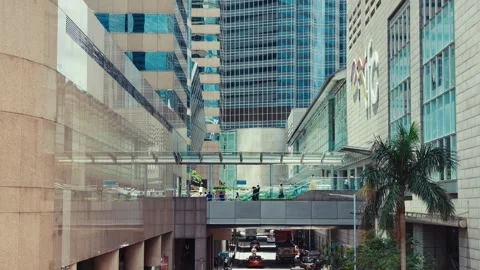A dynamic urban scene featuring a multi-level pedestrian bridge spanning over a Stock Footage 338311427