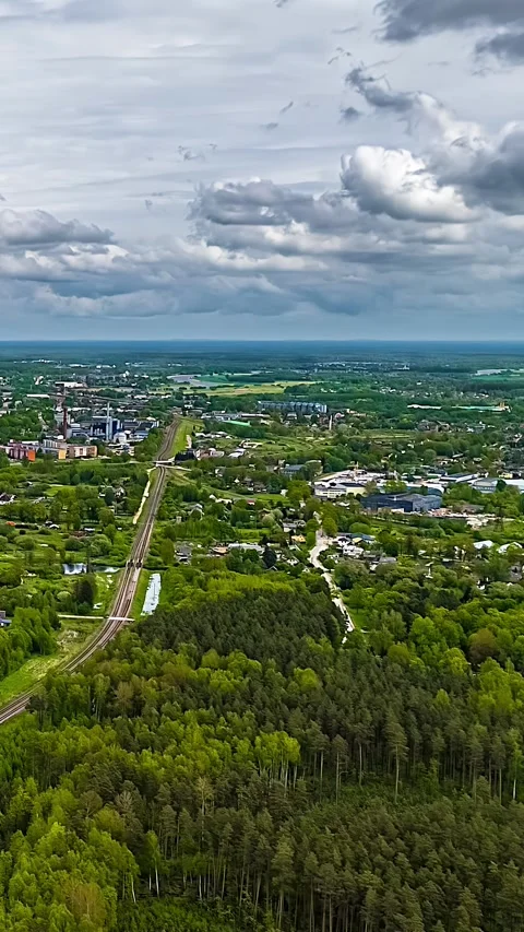 Dynamic Vertical Hyperlapse of City and Lush Landscape Under Moody Skies 스톡 동영상 334092551