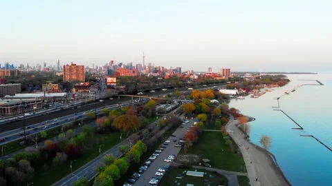 Dynamic video of busy metropolis with dense green trees along highway. Drone Stock Footage 254686126