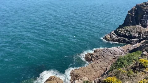 Dynamic View from Above of Crashing Waves on Brittany's Coastal Rocks Stock Footage 314990578