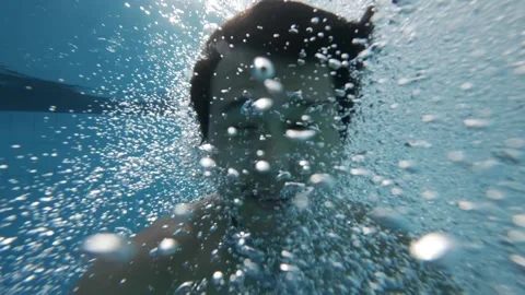 Dynamic view from below as a man enters the pool Stock Footage 340535935