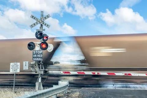 Dynamic view of a coal train passing through a rural railway crossing Stock Photos