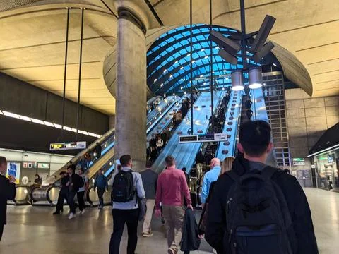 Dynamic view of commuters on escalators in Londons modern Canary Wharf transport Stock Photos