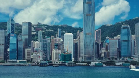 A dynamic view of Hong Kong's iconic skyline against lush green hills. 库存影片 338311000