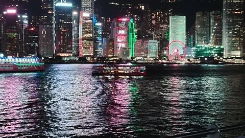 A dynamic view of Hong Kong's vibrant night skyline centered on the bustling Stock Footage 338280479