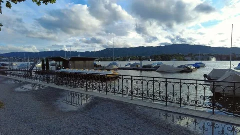 Dynamic view of a lake pier with anchored boats and a metal fence Stock Footage 337930798