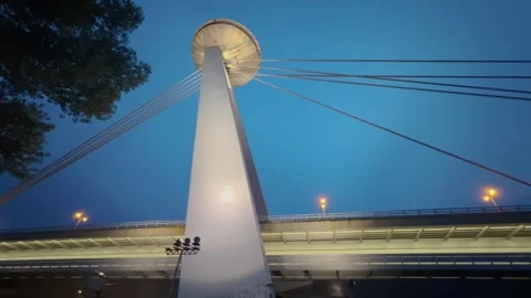 A dynamic view of a modern cable-stayed bridge, captured from below at dusk. Stock Footage 299946424