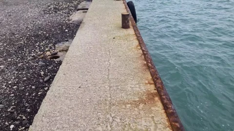Dynamic view of old concrete pier beside calm blue coastal water Stock Footage 321651081
