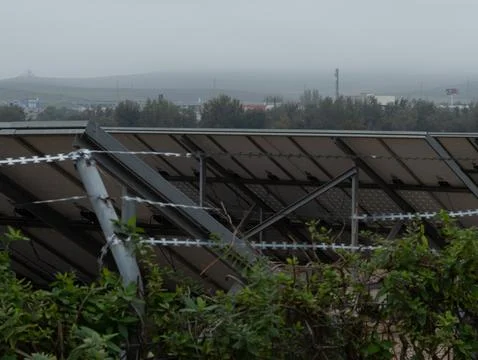 A dynamic view of solar panels against a rainy sky, showcasing their importan Stock Photos