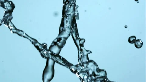 Dynamic water splashes and drops move across a blue background Stock Footage 326628219