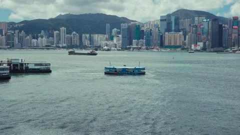 A dynamic waterfront view of Hong Kong with a busy skyline and various boats 库存影片 338311007