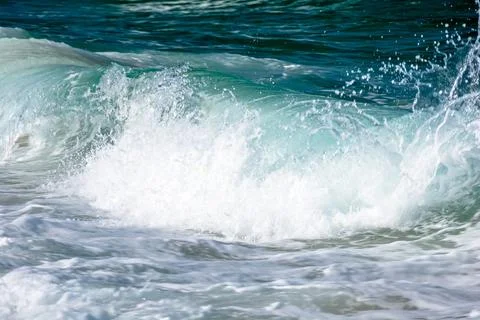Dynamic wave crashes sandy beach in afternoon Stock Photos
