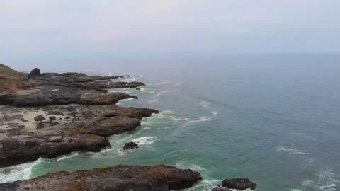 Dynamic Waves Crash Against Rugged Volcanic Rock Formations at Cape Perpetua Sce Stock Footage 326712893